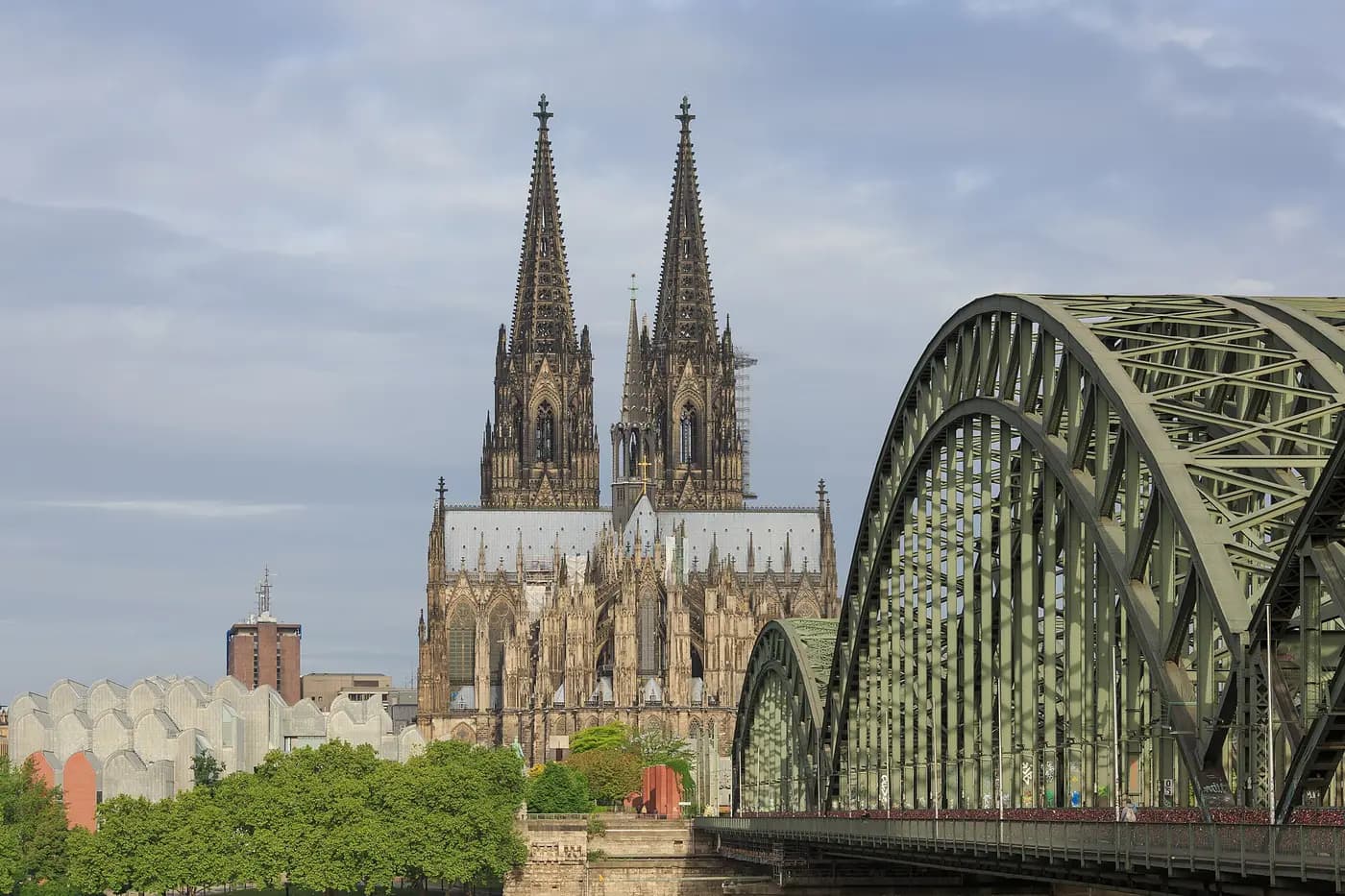 Cologne Cathedral's twin spires beside the steel arches of the Hohenzollern Bridge