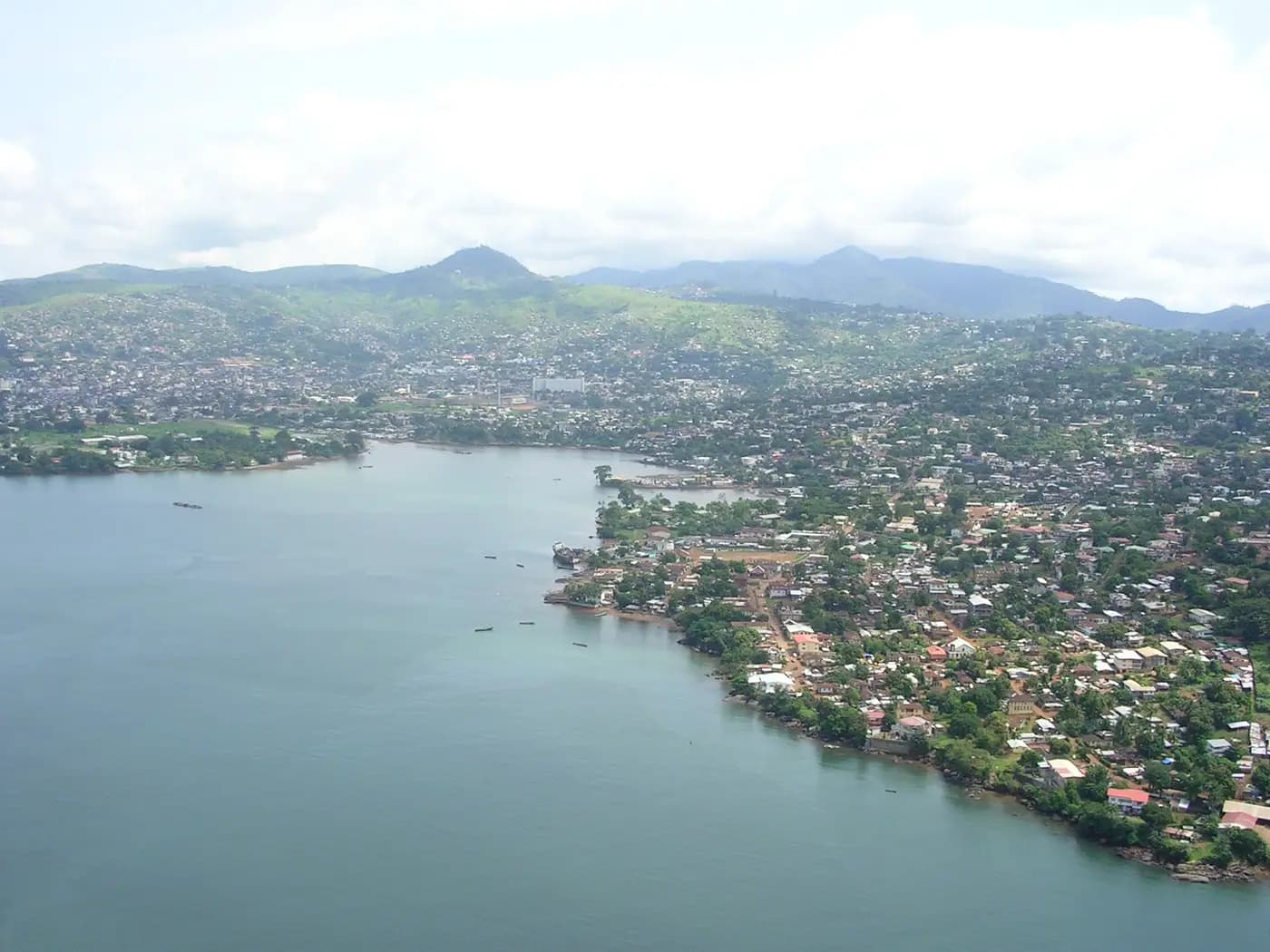 Freetown spreading over the green hills and shoreline of the Sierra Leone River estuary, seen from the air
