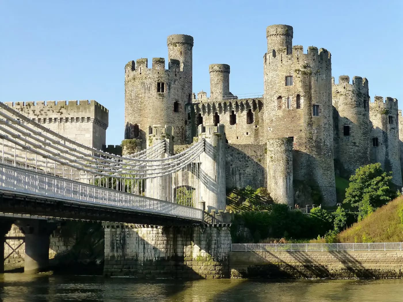 The round towers of Conwy Castle rising behind Telford's suspension bridge over the River Conwy