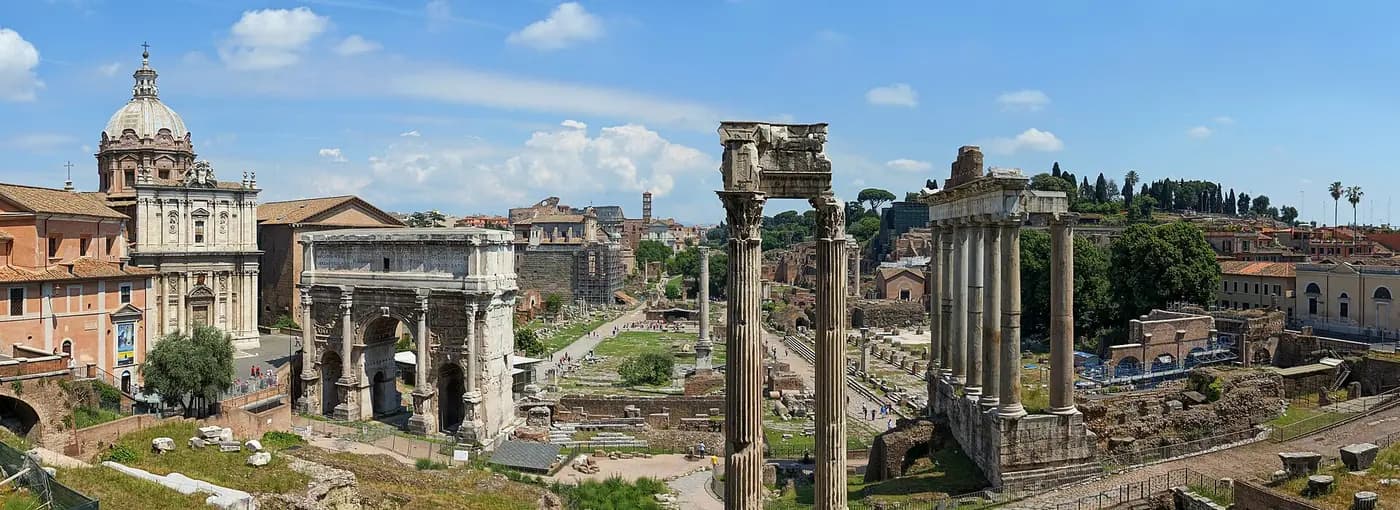 The Roman Forum's ruined temples and columns seen from above, with Rome beyond