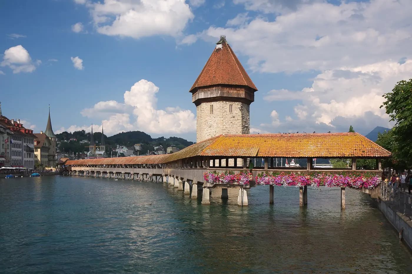 The covered wooden Chapel Bridge and its stone water tower across the River Reuss in Lucerne
