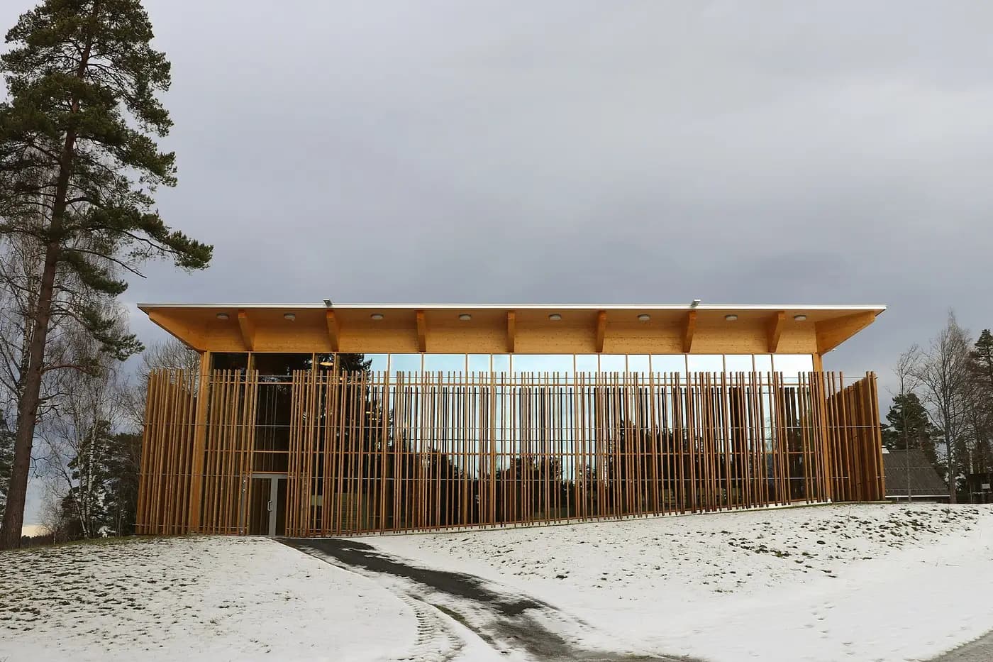 Hegnhuset, the learning centre on Utøya, ringed by a screen of wooden posts in the snow