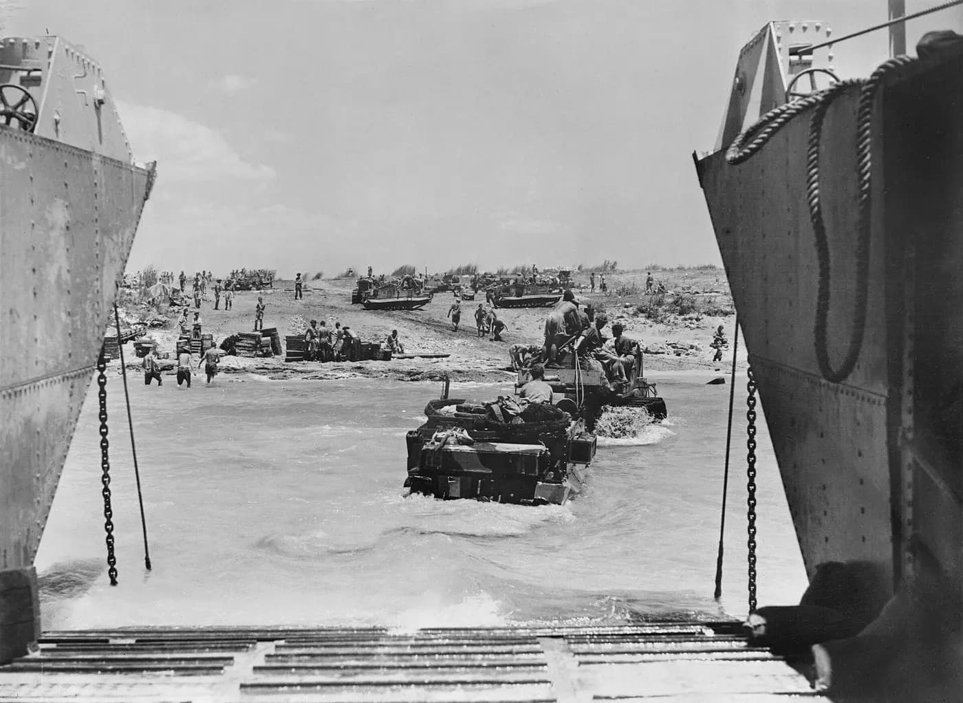 Vehicles leave a landing ship's open bow doors for a Sicilian beach on 10 July 1943