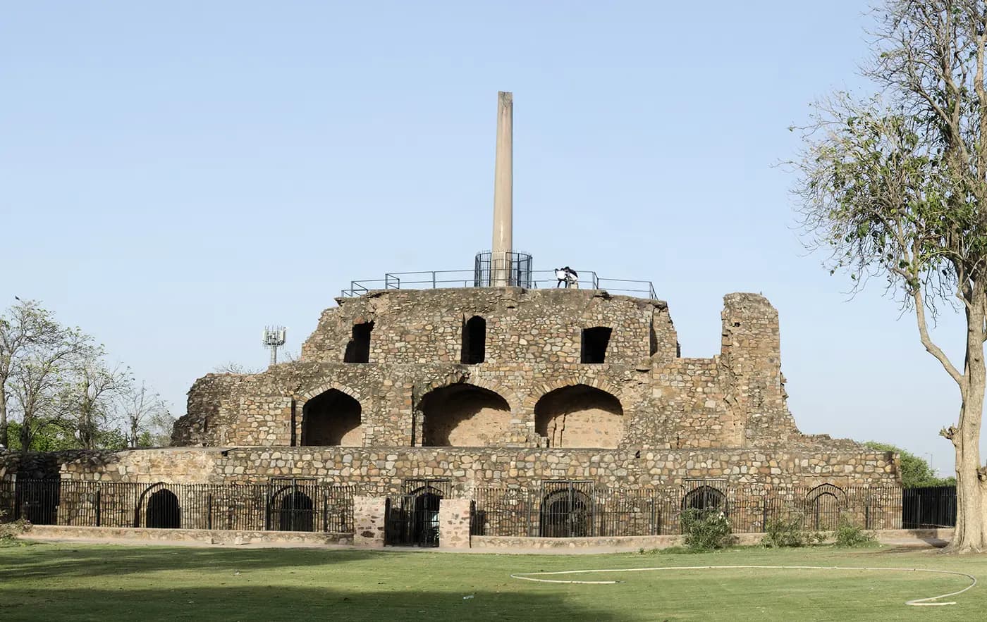 Ashoka's polished stone pillar standing on the ruined arcaded terrace of Feroz Shah Kotla, Delhi