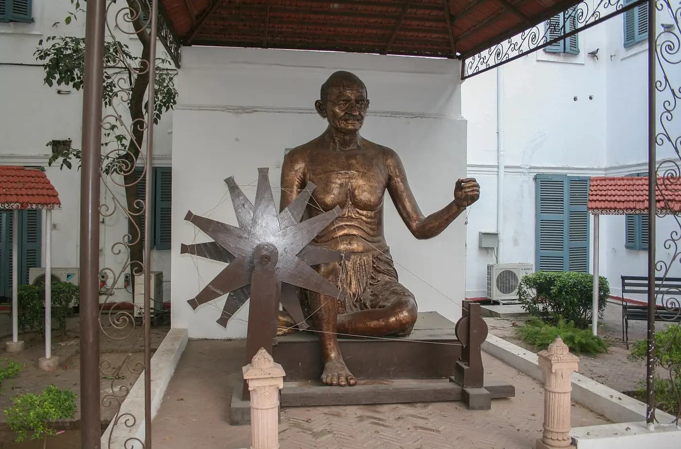 Bronze statue of Gandhi at a spinning wheel in the grounds of Gandhi Smriti, Delhi