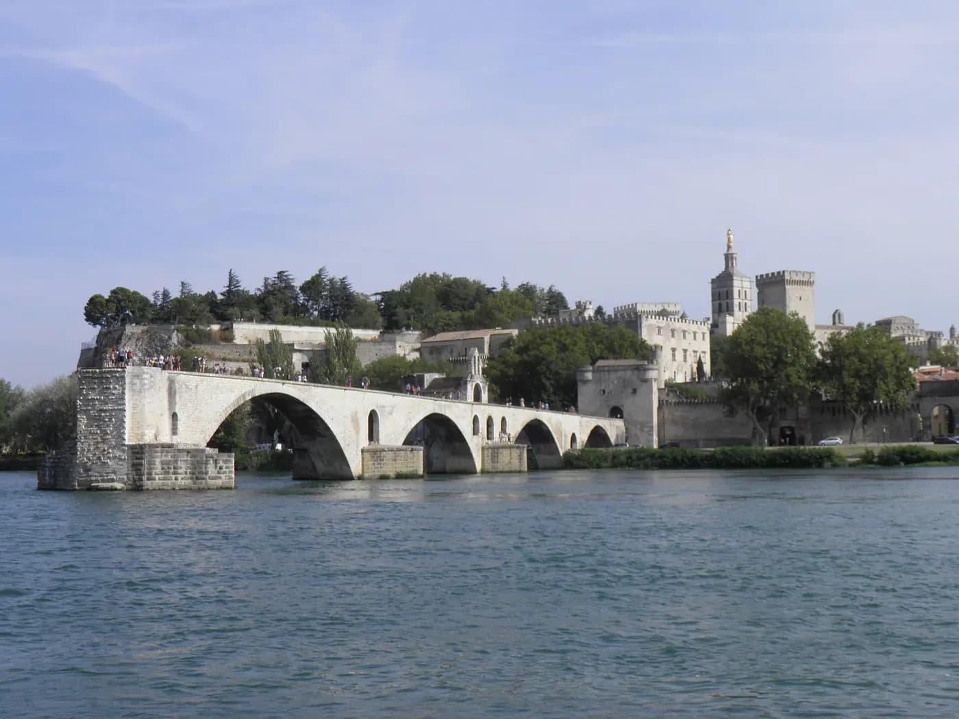 The broken arches of the Pont Saint-Bénézet across the Rhône, with the Palais des Papes beyond