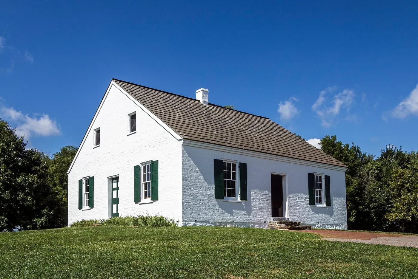 The small whitewashed Dunker Church standing in open fields on the Antietam battlefield