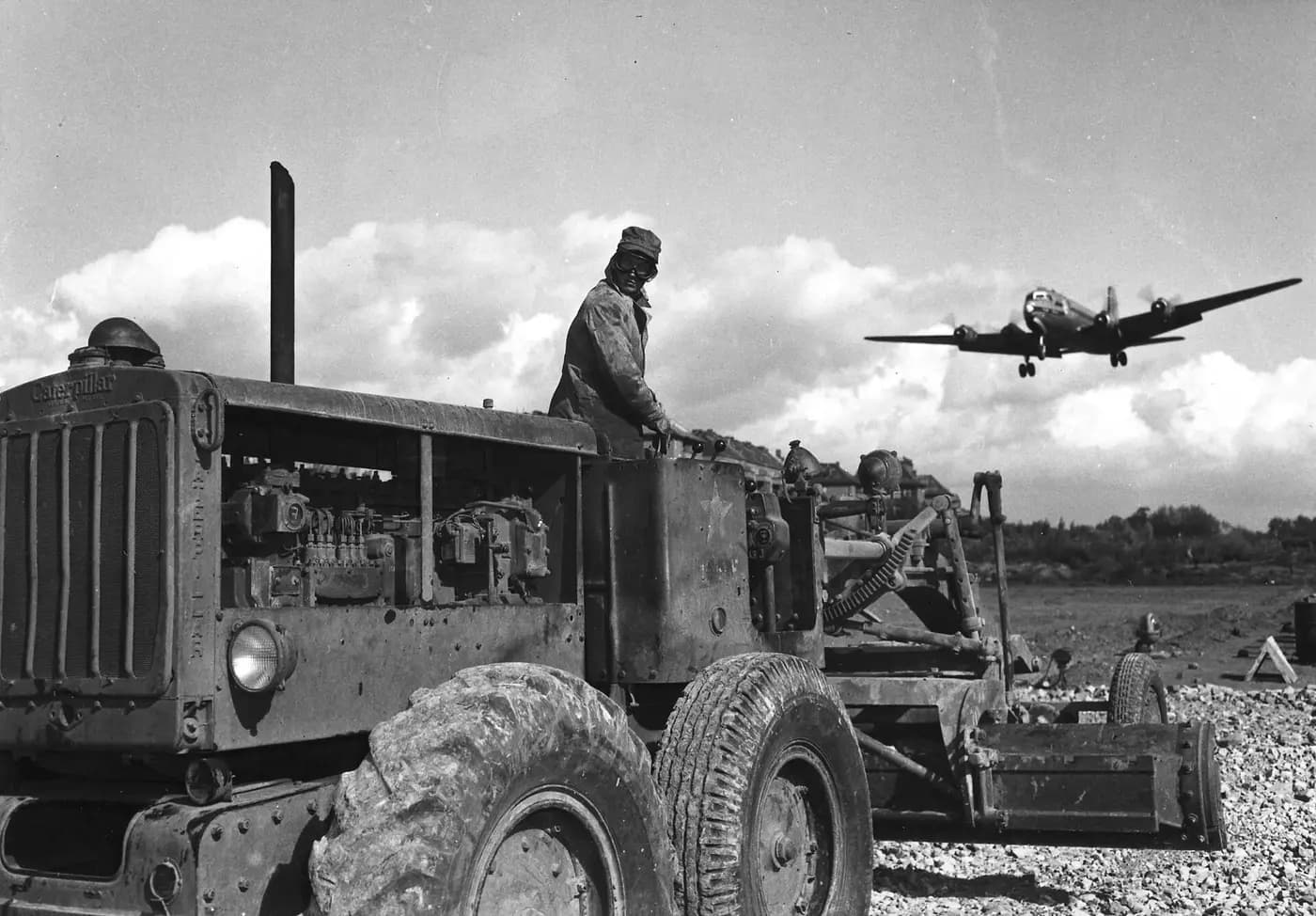 A C-54 transport lands at Tempelhof in 1948 while a grader works on the airfield during the airlift