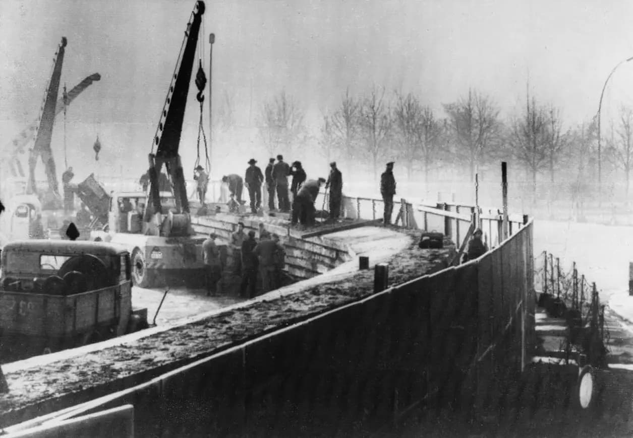 East German workers using cranes to raise the Berlin Wall in November 1961