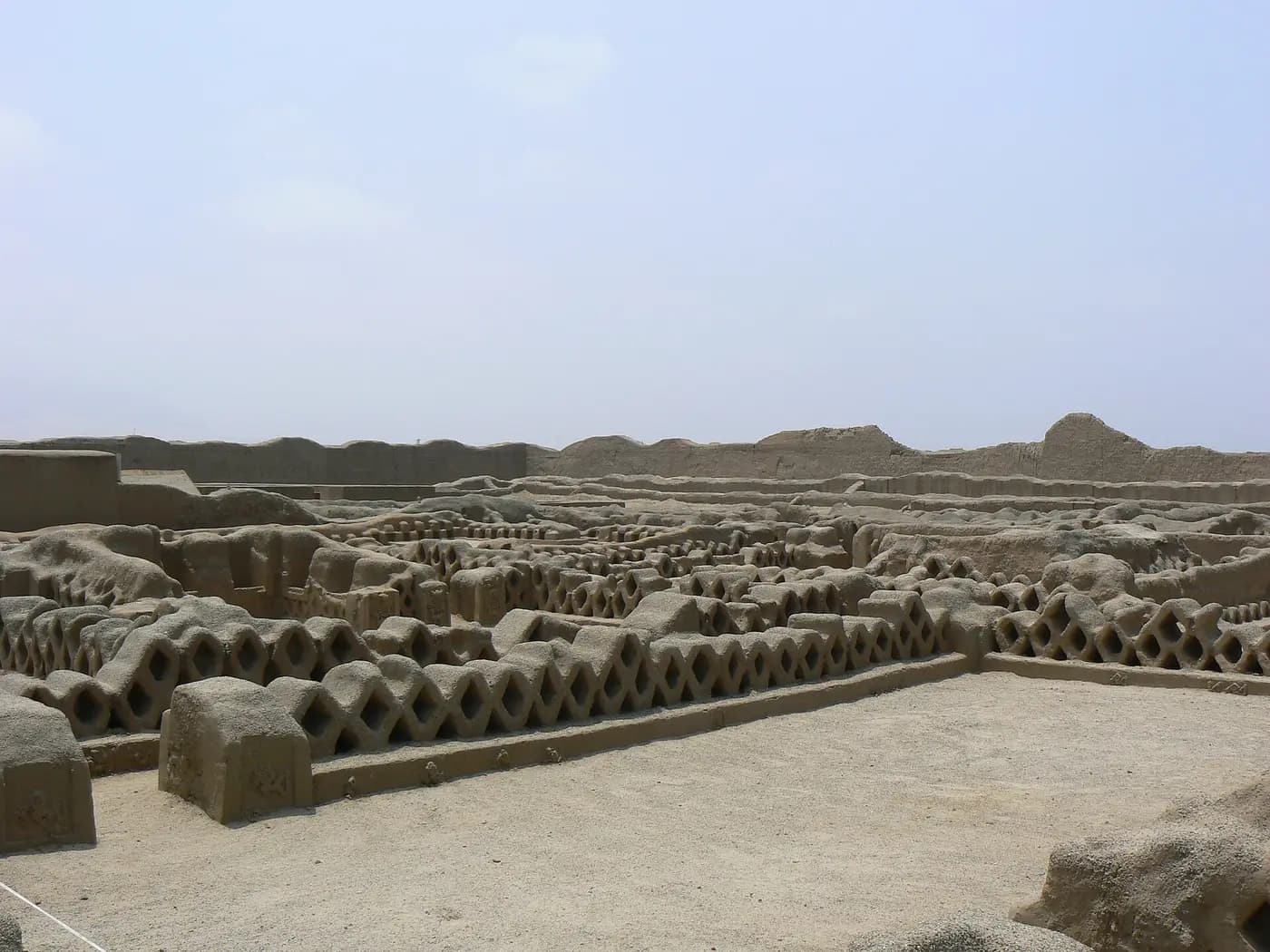 Adobe walls with a lattice fishnet pattern in the Tschudi palace at Chan Chan