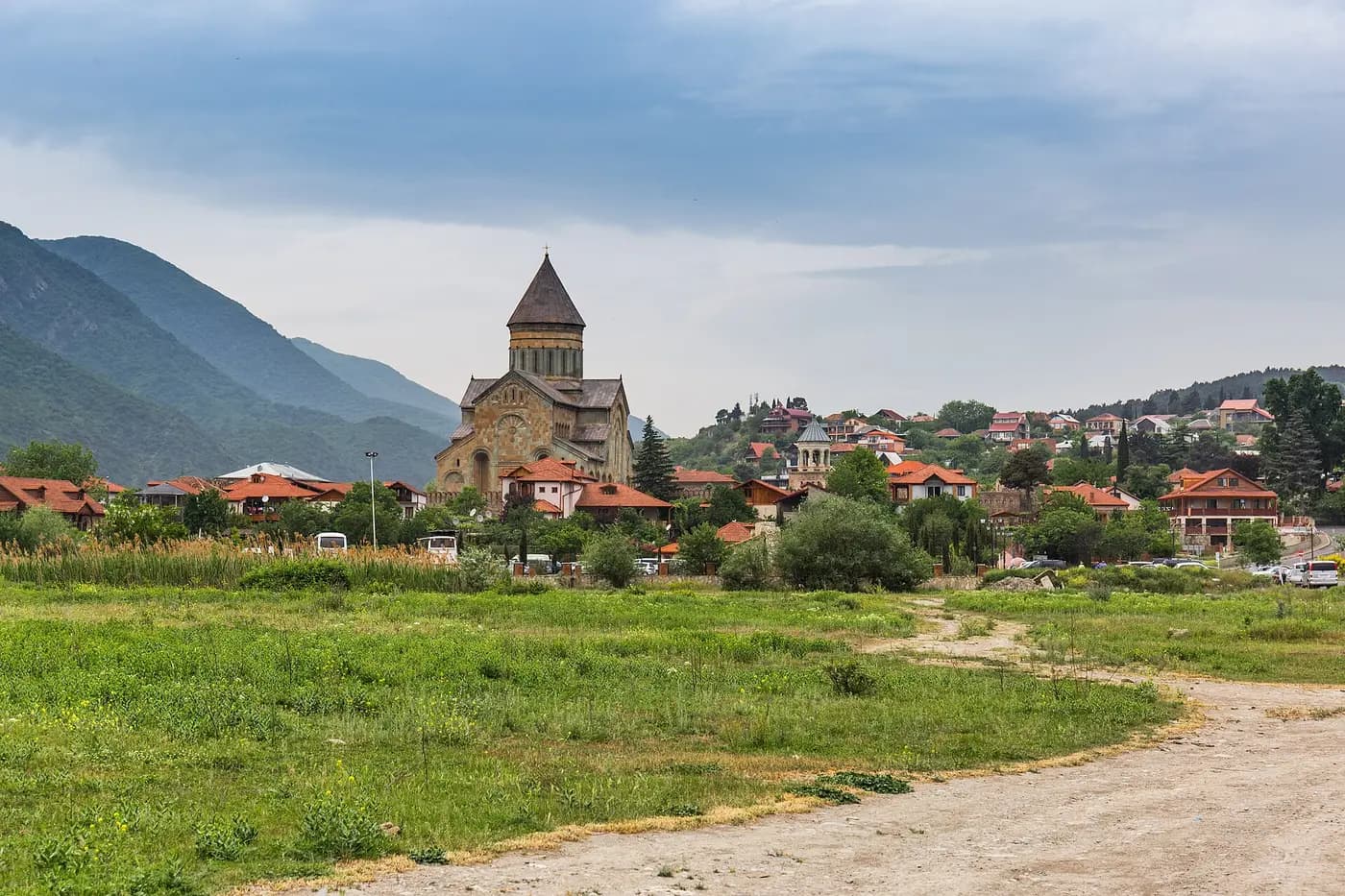 Svetitskhoveli Cathedral rising above the rooftops of Mtskheta, with green mountains behind