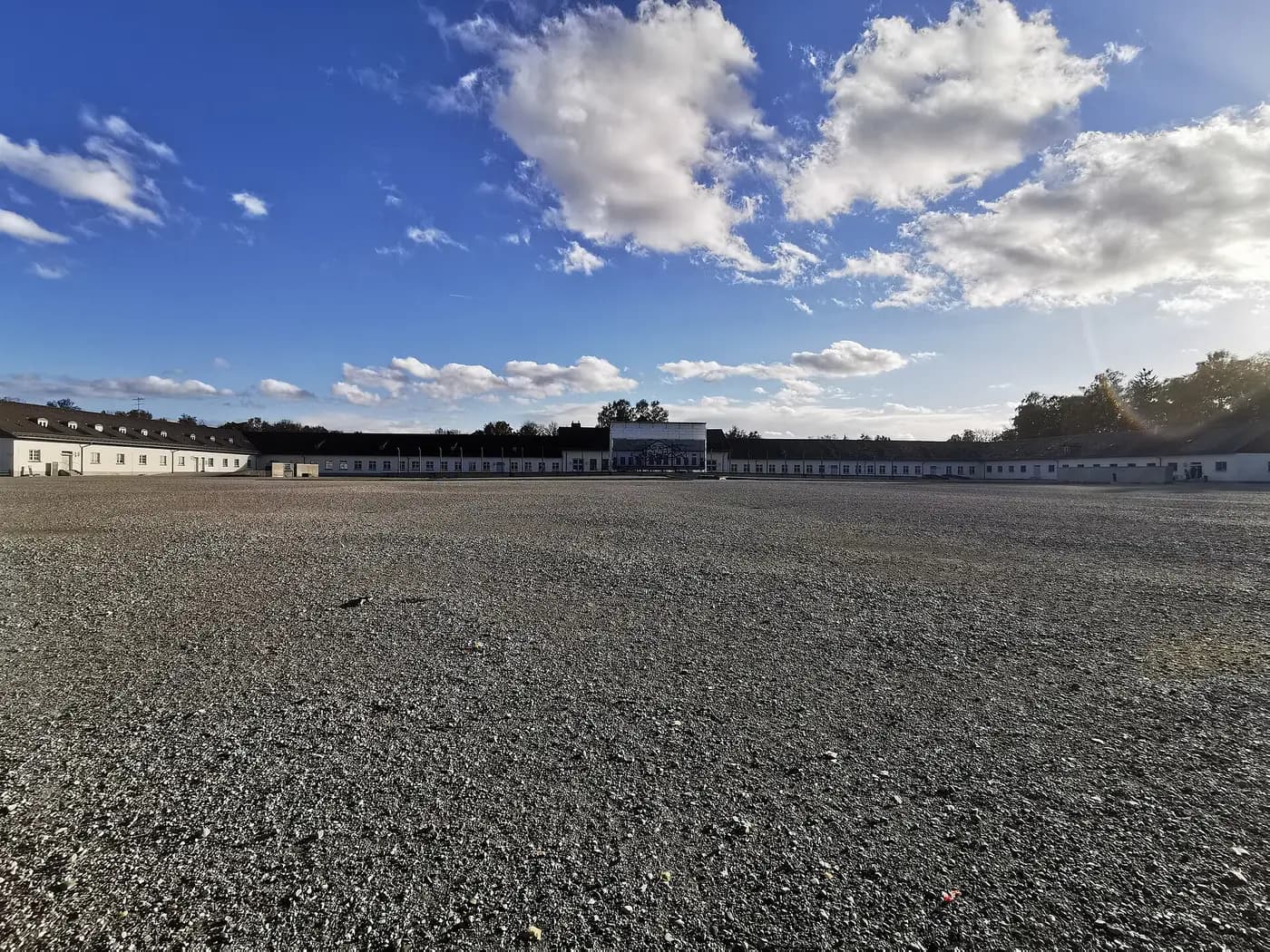 The vast roll-call square at the Dachau memorial, with the former camp buildings on its far side