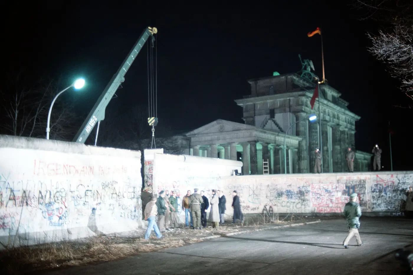 A crane removes a section of the Berlin Wall beside the Brandenburg Gate in 1989