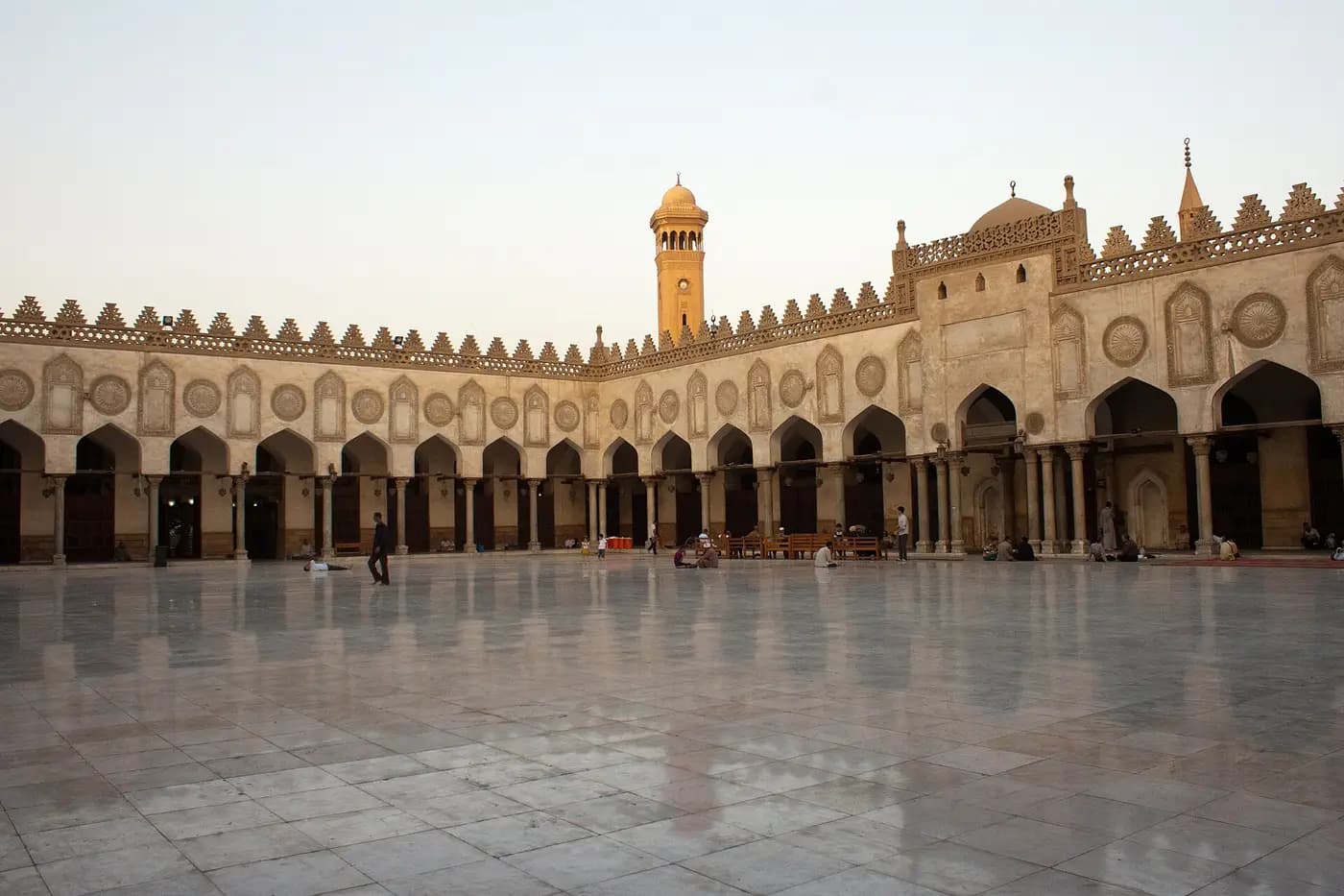 Marble courtyard of al-Azhar Mosque ringed by arcades, with a minaret in early light