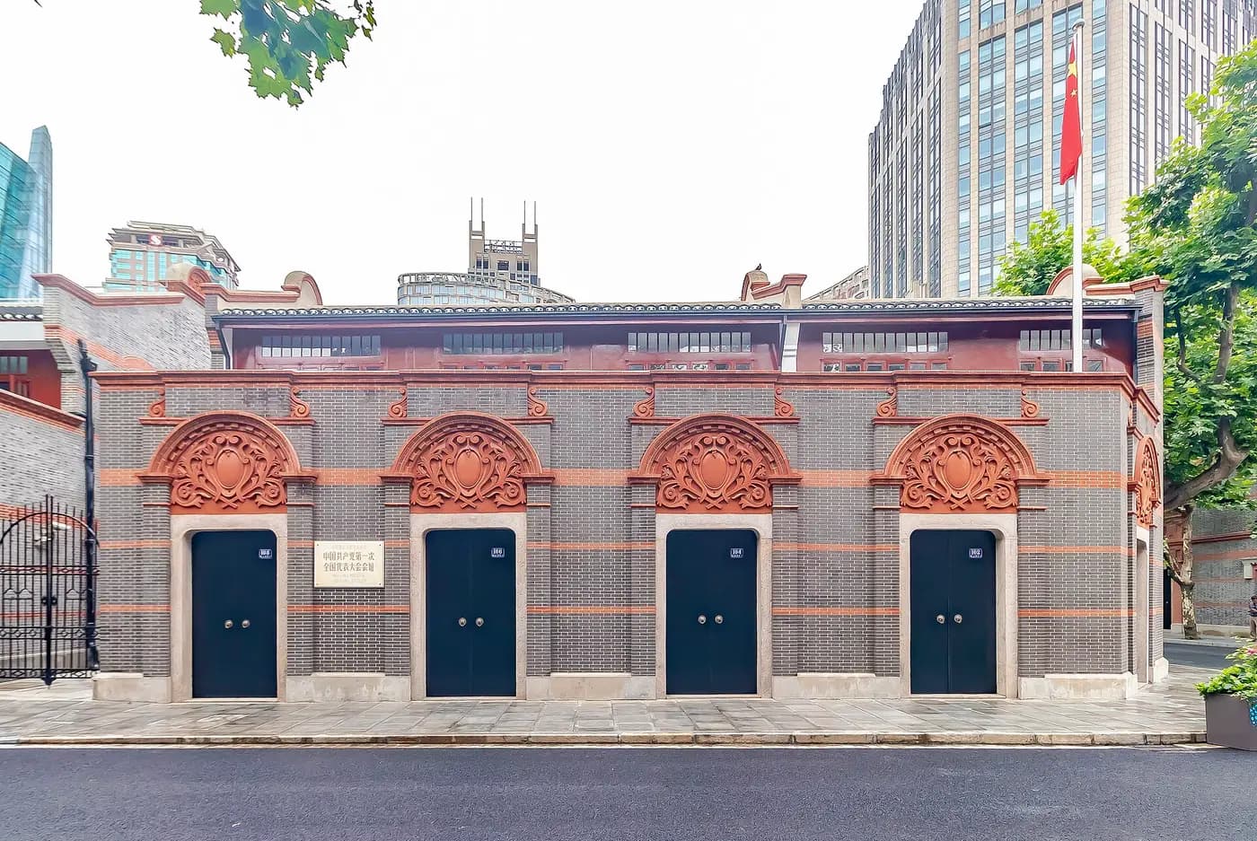 Grey-brick shikumen house fronts with carved red lintels at the First Congress site in Shanghai