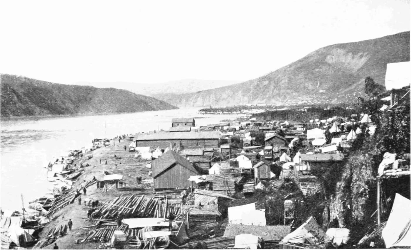 Dawson in 1898: timber buildings and tents crowded along the bank of the Yukon River