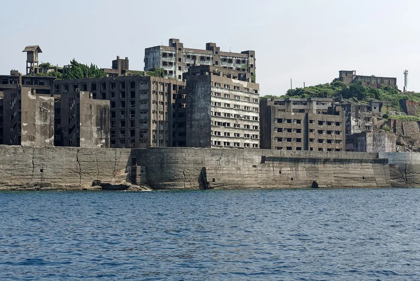 Abandoned concrete apartment blocks rise behind the sea wall of Hashima island off Nagasaki