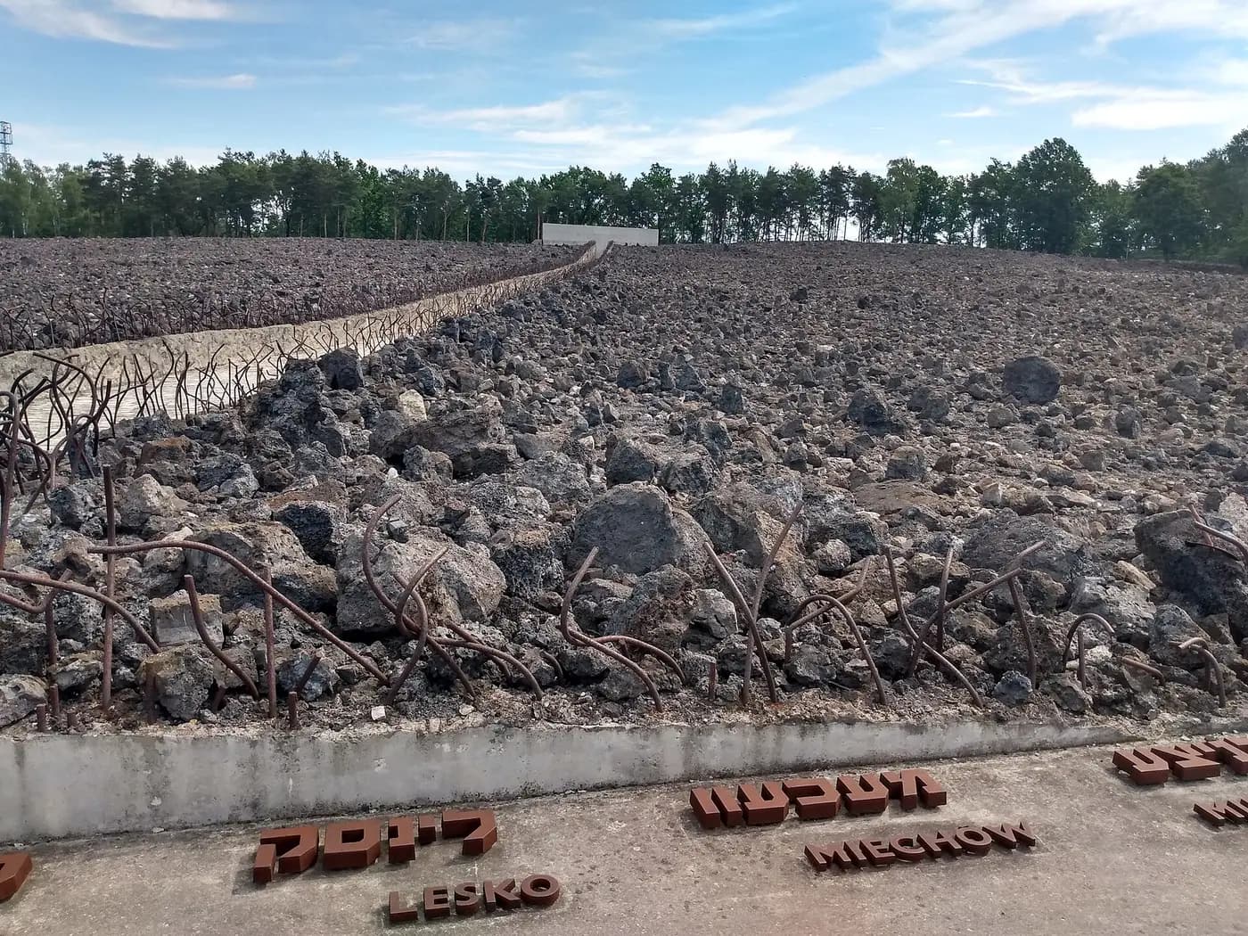 The Bełżec memorial: a field of dark stones over the former camp, edged with names of deported towns