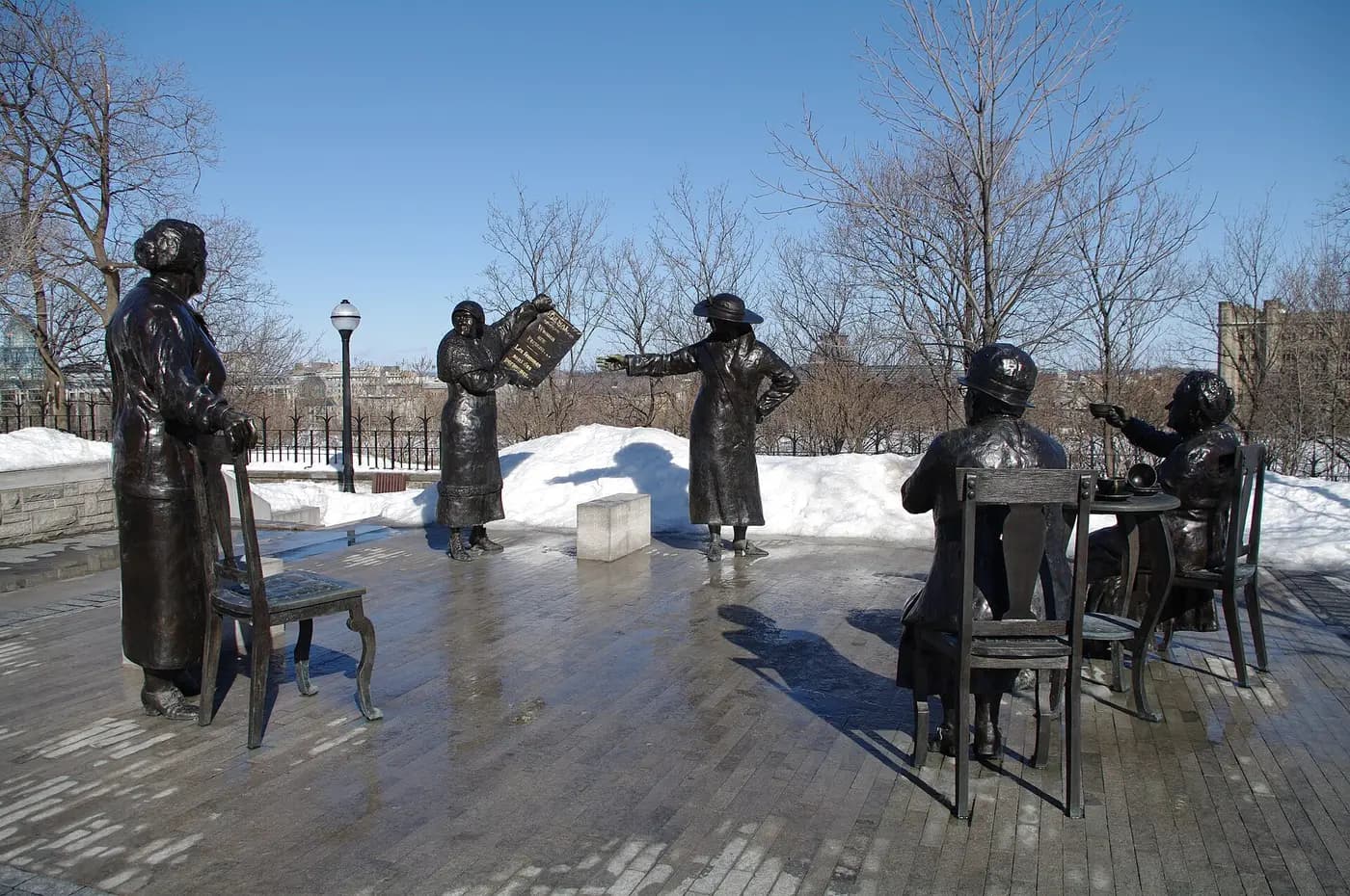 Bronze statues of the Famous Five on Parliament Hill, Ottawa, one holding a newspaper reading Women are Persons