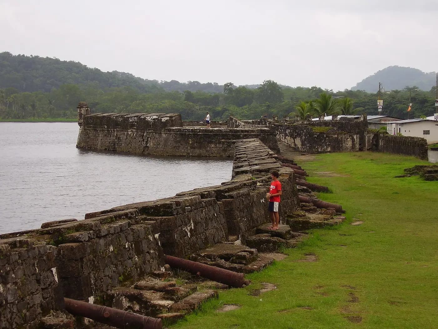 Stone ramparts of Fort San Jerónimo running along Portobelo Bay, with old cannon on the walls