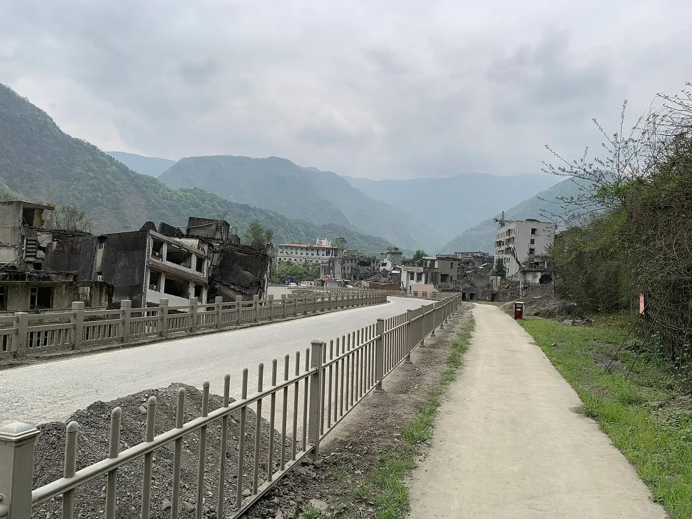 A path leads into old Beichuan, its shattered buildings left standing in a mountain valley