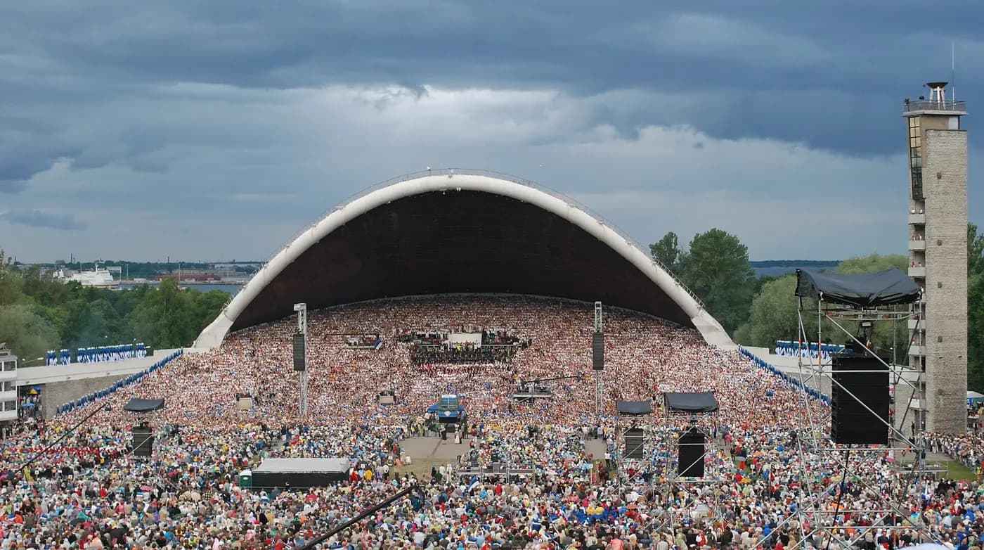 A vast crowd fills the Tallinn Song Festival Grounds before the arched song stage
