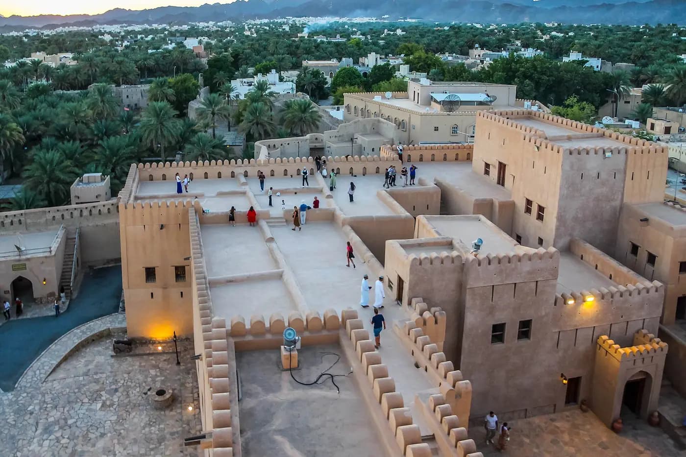 Crenellated walls and courtyards of Nizwa Fort above the town and its palm groves