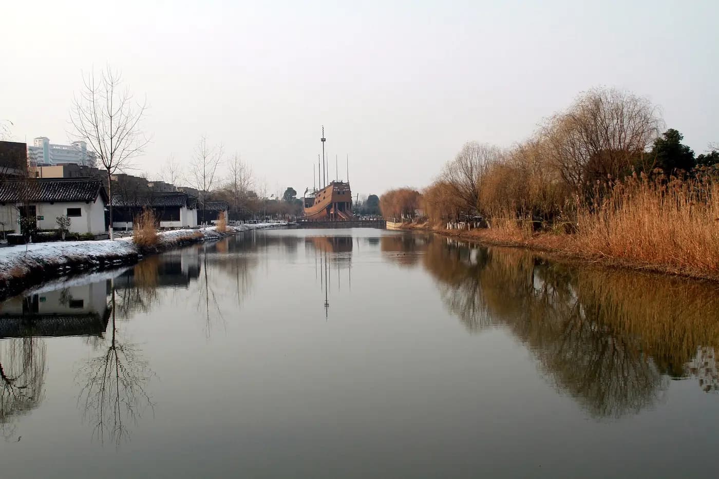 Long dock basin of the Ming treasure shipyard in Nanjing, with a replica ship beyond