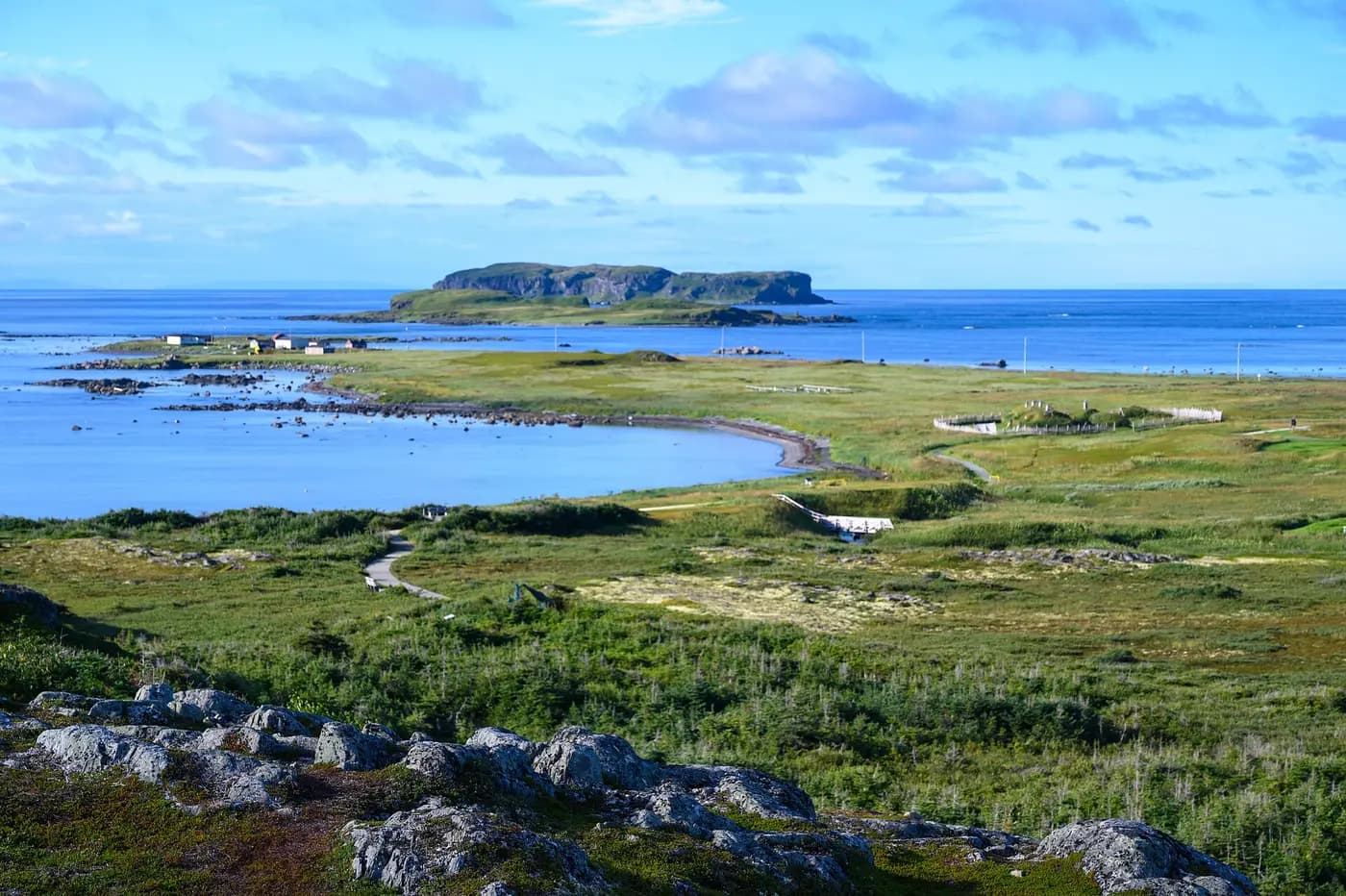 Grassy coastal plain of the Norse site at L'Anse aux Meadows, with sea and islands beyond