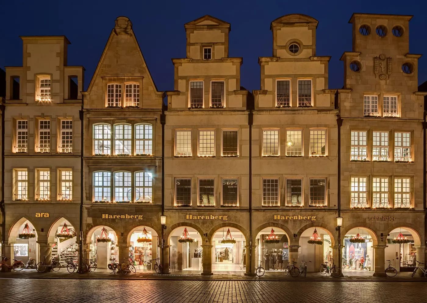 Gabled merchants' houses with arcades along Münster's Prinzipalmarkt, lit up at dusk