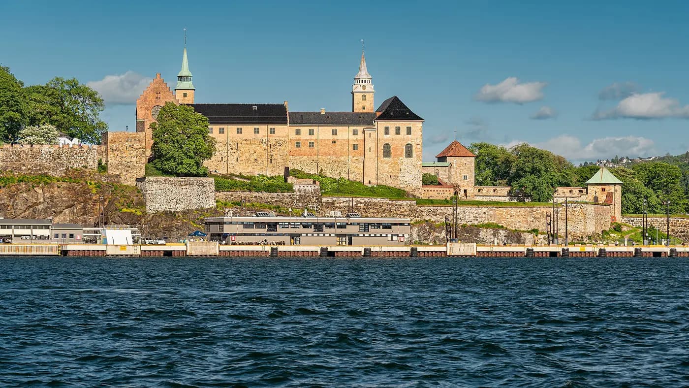 Akershus Fortress and its castle towers above the harbour wall, seen from the water in Oslo