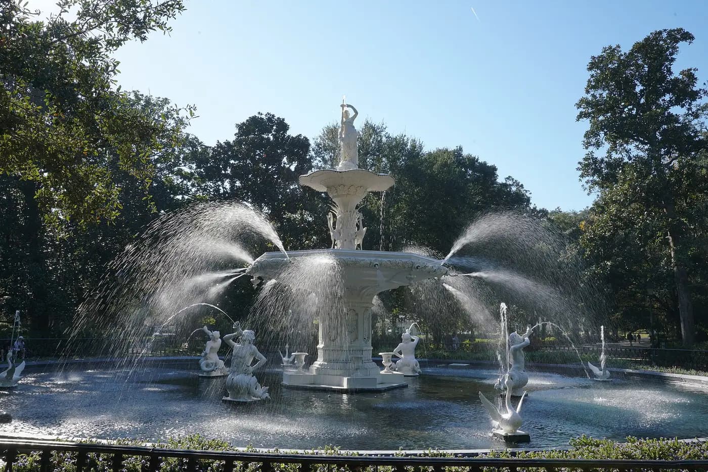 The white cast-iron fountain of 1858 in Forsyth Park, Savannah, framed by oak trees