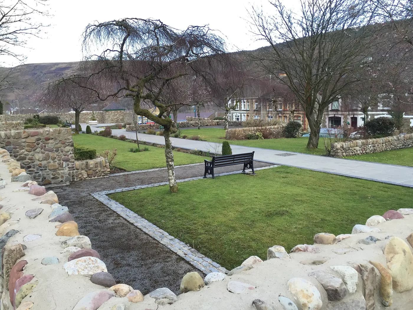 The memorial garden laid out on the site of Pantglas school in Aberfan, with paths, lawns and a bench