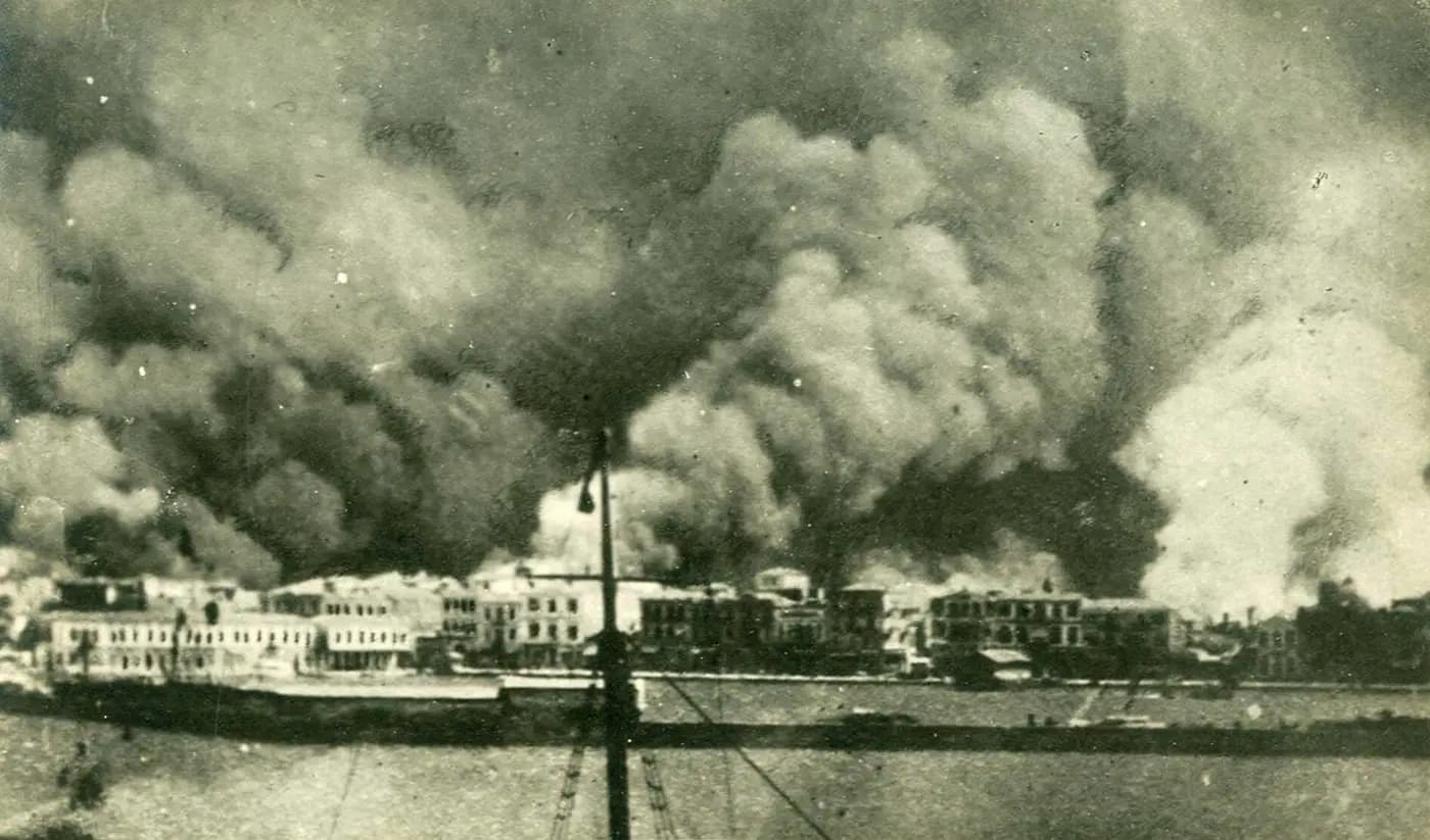 Smoke billows over Smyrna's waterfront buildings during the great fire of September 1922, seen from a ship