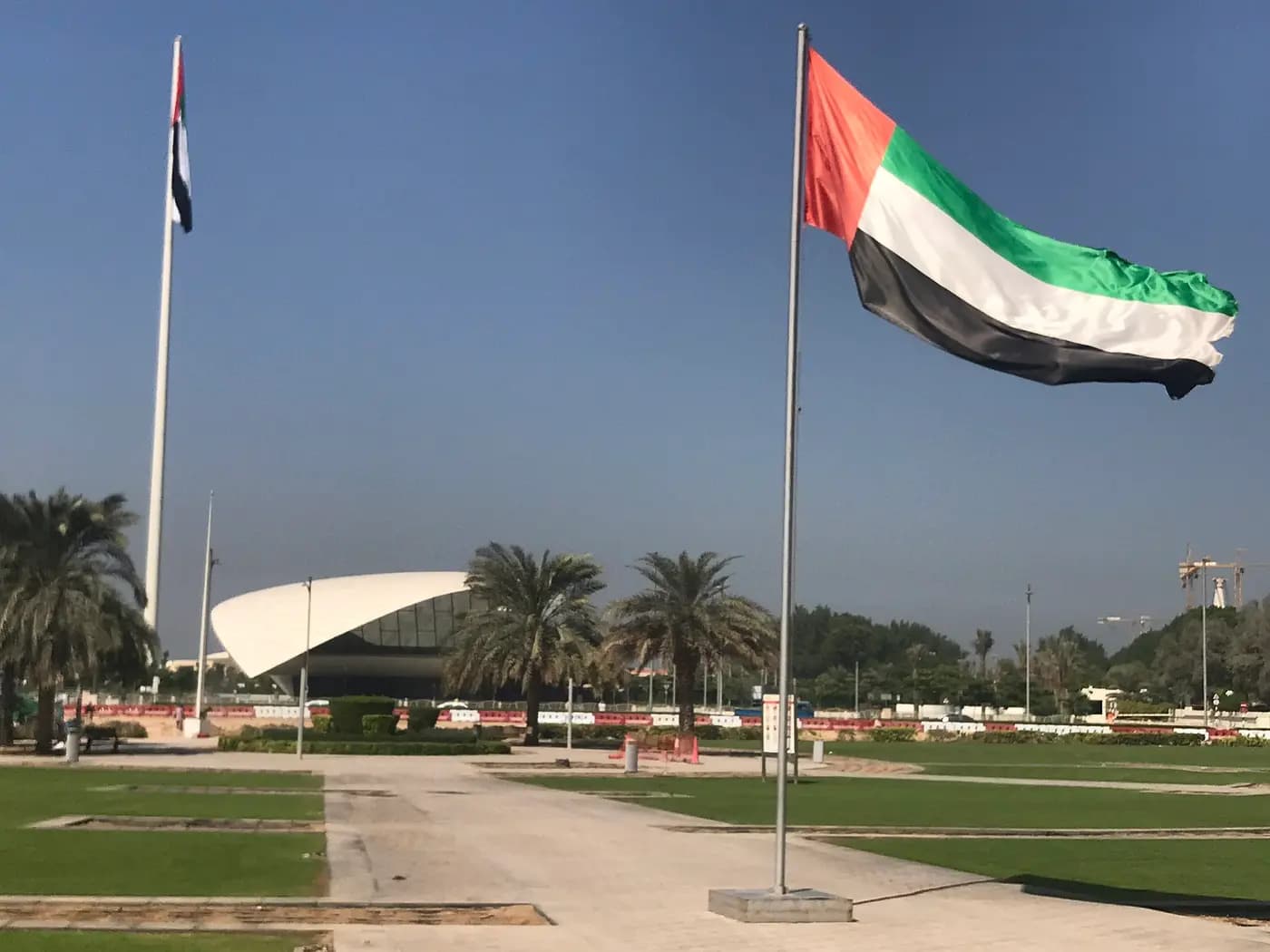 The UAE flag flying over the grounds of Union House, with the Etihad Museum behind