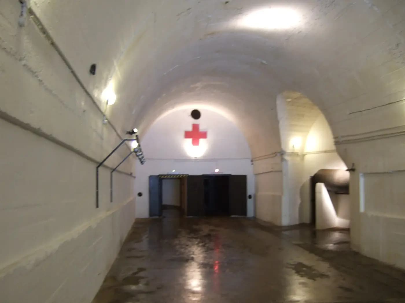 A whitewashed tunnel marked with a red cross inside the Jersey War Tunnels, the German underground hospital