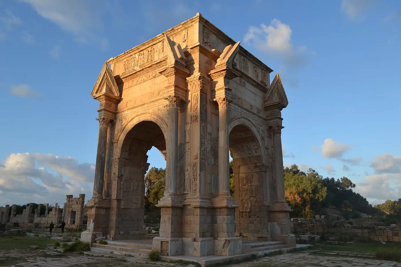 The four-sided Arch of Septimius Severus at Leptis Magna, with ruined colonnades behind